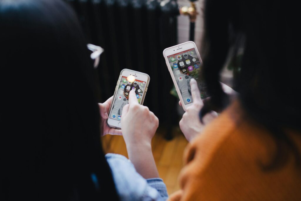 two women operating smartphones